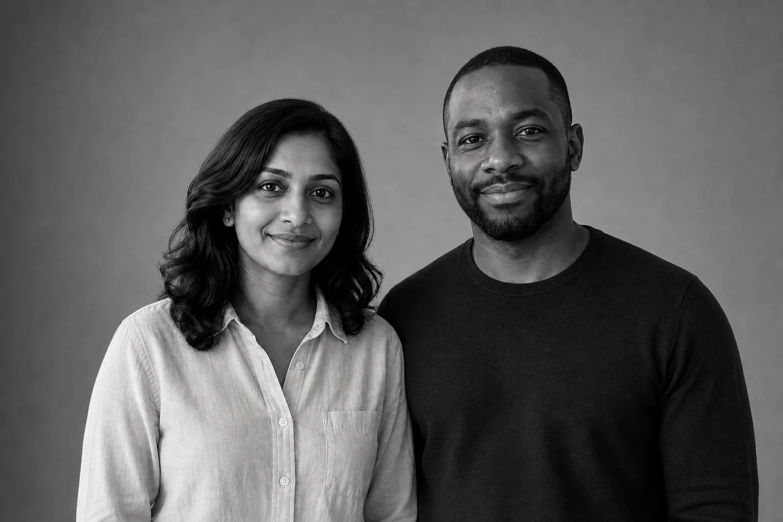 Black-and-white studio edit of the fictional couple with a plain gray backdrop